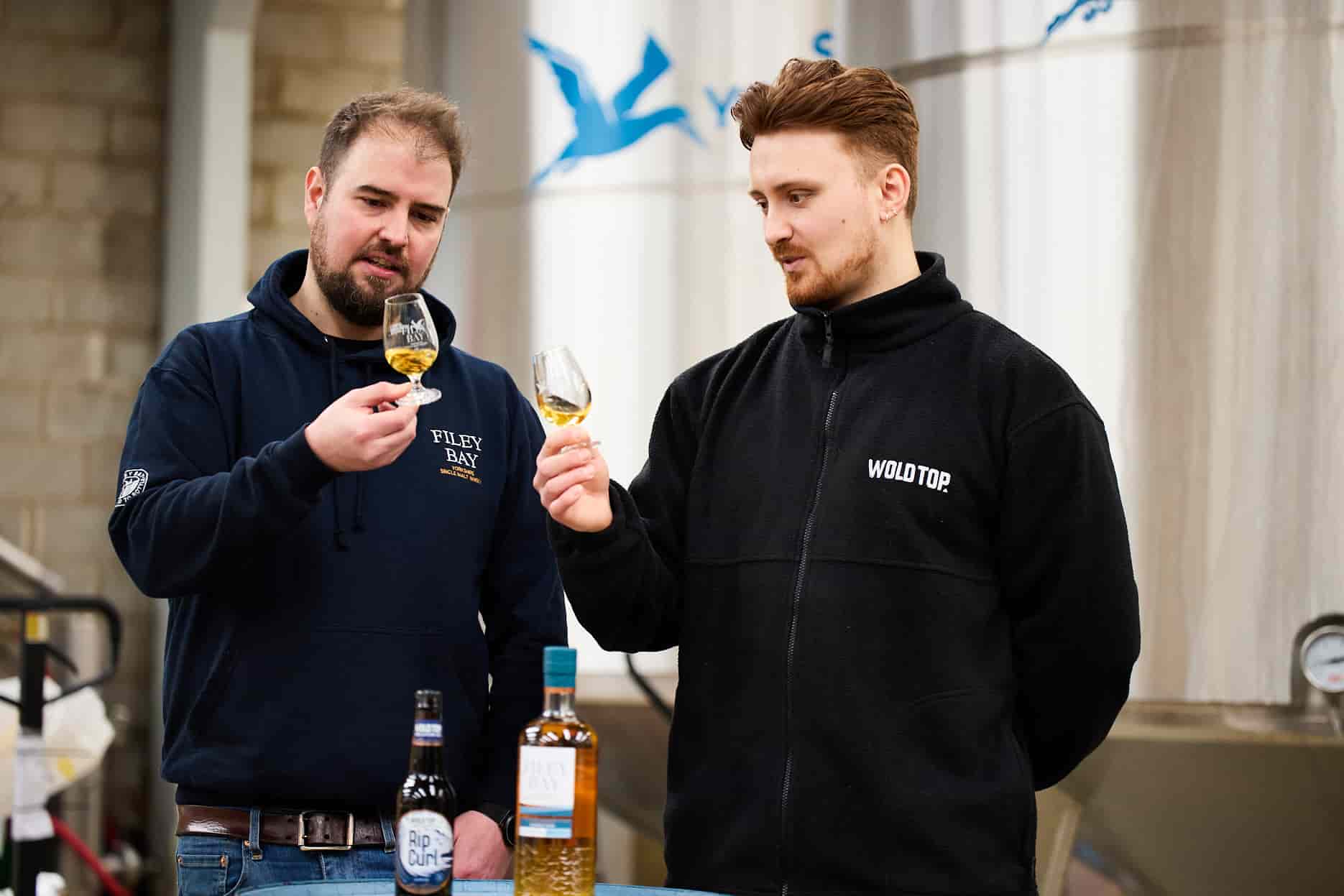 Two team members from Filey Bay Whisky look at Filey Bay Porter Cask #2 Single Malt Whisky in a glass.